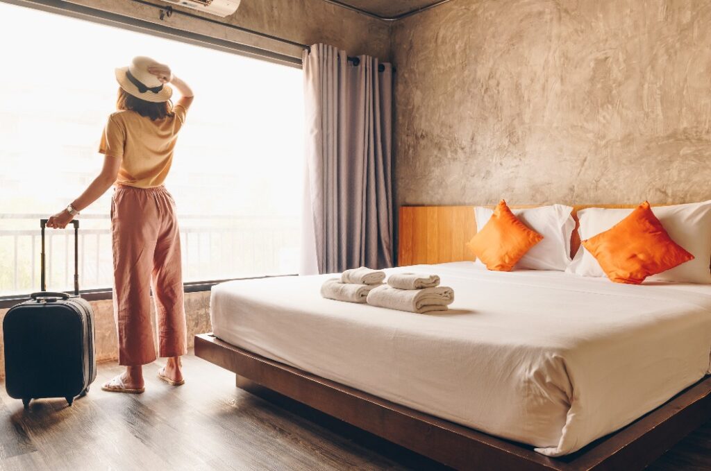 Porträt einer Touristin, die am Fenster steht und nach draußen schaut